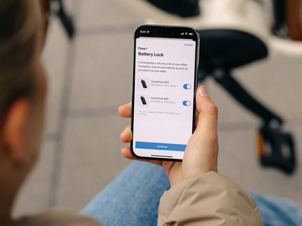 Mano che regge uno smartphone con la schermata Battery Lock dell'app Bosch Flow